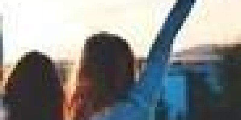 Uzun saçlı iki kadın arkaları dönük şekilde güneş batışında birbirlerine sarılarak poz vermişler. Kadınlardan birinin eli havada ve zafer işaret yapıyor.
