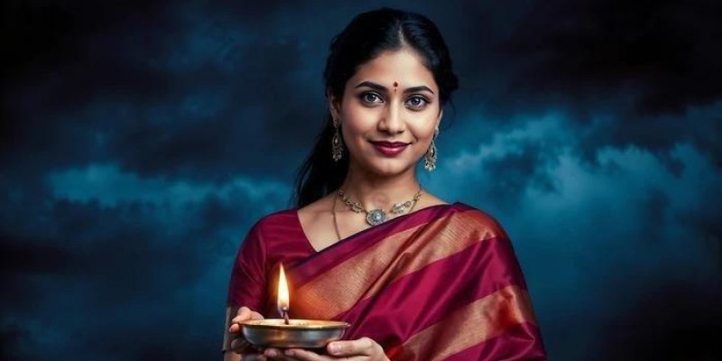 Geleneksel sarı giymiş bir kadın, iki eliyle küçük metal bir yağ lambası tutarken. Lambanın içinde yanan tek bir alev var ve alev öne doğru hafifçe yükseliyor. Kadının saçları ortadan ayrılmış ve arkaya doğru toplanmış. Alnının ortasında kırmızı bir benek (bindi) var. Küpe ve kolye takıyor. Sarisi bordo tonlarında ve üzerinde altın renkli şeritli bir bordür bulunuyor. Yüz ifadesi hafif gülümsemeli; doğrudan kameraya dönük. Arka plan koyu mavi tonlarda, bulutlu bir gökyüzünü andıran yumuşak geçiş