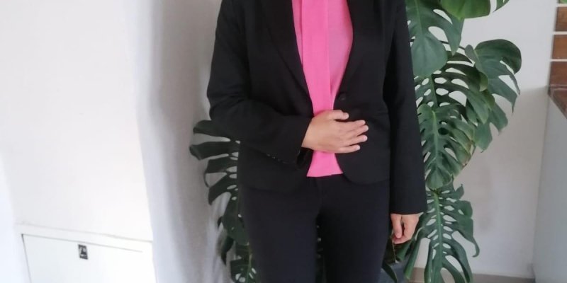 Konuk Zuhal Karın, Orta yaşlı bir kadın. İç mekanda, arkası duvara yakın ayakta duruyor. Arkasında büyük saksıda bir çiçek var. Açık tenli, saçları dalgalı, kulak hizasında. Siyah ceket ve pantolon giyinmiş. Pembe bluzu var. Sağ elini, ceketinin sol yakasına götürmüş. Gülümsüyor.