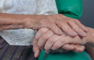 İki kişinin birbirinin üzerinde elleri görünüyor. El derisinin buruşukluğundan, üst tarafta görünen elin daha yaşlı birine ait olduğu anlaşılıyor. Diğer el daha açık tenli ve genç birine ait.