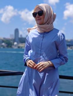 Söyleşide yer alan Merve Karagöz deniz kenarında, açık mavi renkli uzun kollu bir elbise giymiş ve başına açık bej renkte bir başörtüsü takmış. Gözlerinde büyük siyah güneş gözlükleri var. Arka planda deniz ve bulanık bir şehir manzarası bulunuyor. Gökyüzü açık ve birkaç beyaz bulut var. Karagöz ellerini önünde birleştirmiş ve hafifçe gülümsüyor.