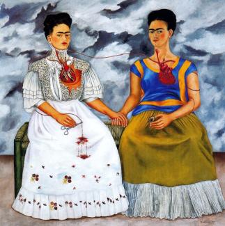 Frida Kahlo'nun "İki Frida" adlı eseri. İki kadın yan yana oturuyor. Soldaki kadın beyaz, dantel detaylı bir elbise giymiş. Kalbi açıkta ve bir damar, elinde tuttuğu makasa bağlı. Sağdaki kadın mavi ve sarı detaylı bir bluz ile yeşil etek giymiş. Onun da kalbi açıkta ve iki kadının kalpleri arasında bir damar bağlantısı var. Kadınlar el ele tutuşmuş. Arka planda bulutlu bir gökyüzü görülüyor.